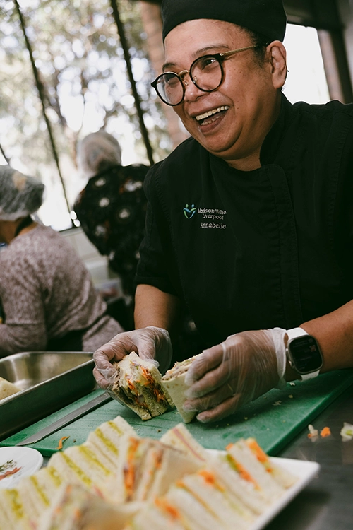 Meals on Wheels staff preparing platter of sandwhiches for catering